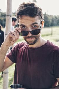 Portrait of man wearing sunglasses while standing outdoors