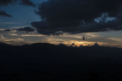 Scenic view of dramatic sky over silhouette landscape