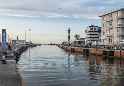 The canal that divides cattolica from gabicce with the buildings that are reflected in the water 