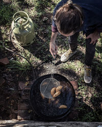 High angle view of man cooking food while standing in yard