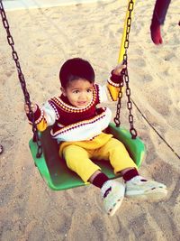 Full length of child on swing at playground