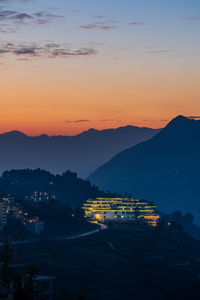 High angle view of illuminated city against sky during sunset