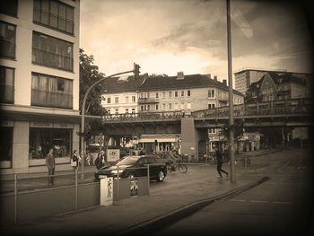Buildings in city against cloudy sky