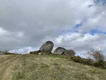 Low angle view of rocks on field against sky