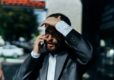 Portrait of young man using mobile phone outdoors