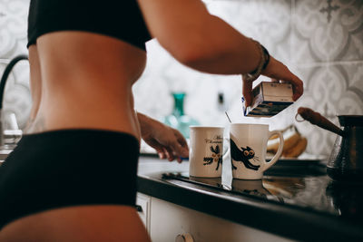 Midsection of woman preparing drink
