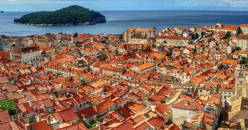 High angle view of city by sea on sunny day