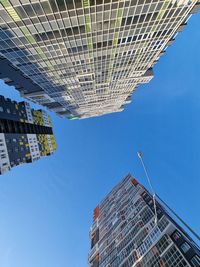 Low angle view of modern buildings against clear blue sky