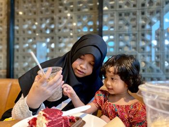 Portrait of mother and son on table in restaurant