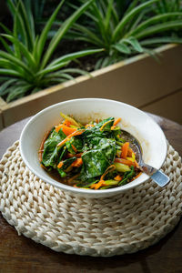 Chinese kale fried in oyster sauce and served in a bowl on the table.