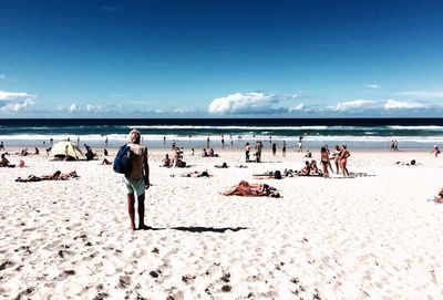 People on beach against blue sky