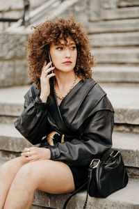 Portrait of young woman sitting outdoors