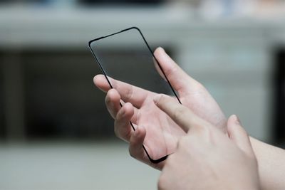 Close-up of hand holding mobile phone