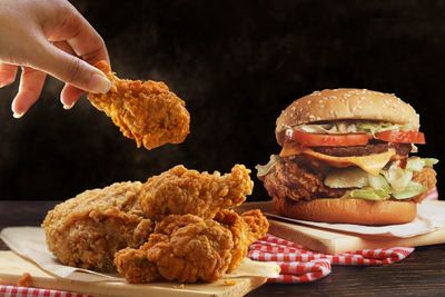 Chicken wings with beef burger on wood table with copy space.