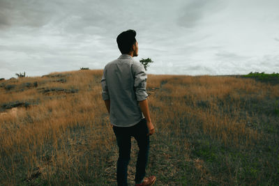 Rear view of man standing on grassy field