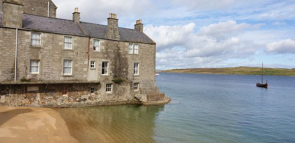 Building by sea against sky