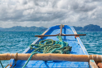 Close-up of fishing boat on sea against sky