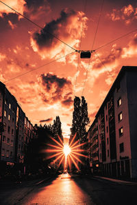 Street amidst buildings against sky during sunset