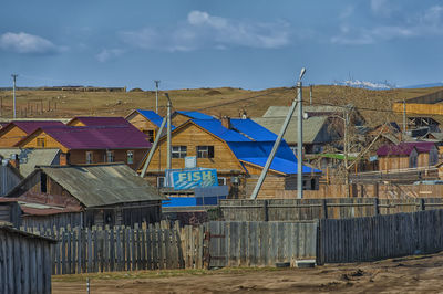 Houses on beach by buildings against sky in city