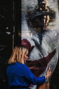 Portrait of woman looking through window