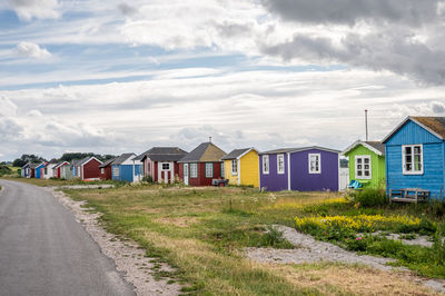 Houses by road against sky