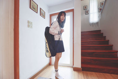 Portrait of young woman standing on staircase