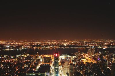 Illuminated cityscape against sky at night