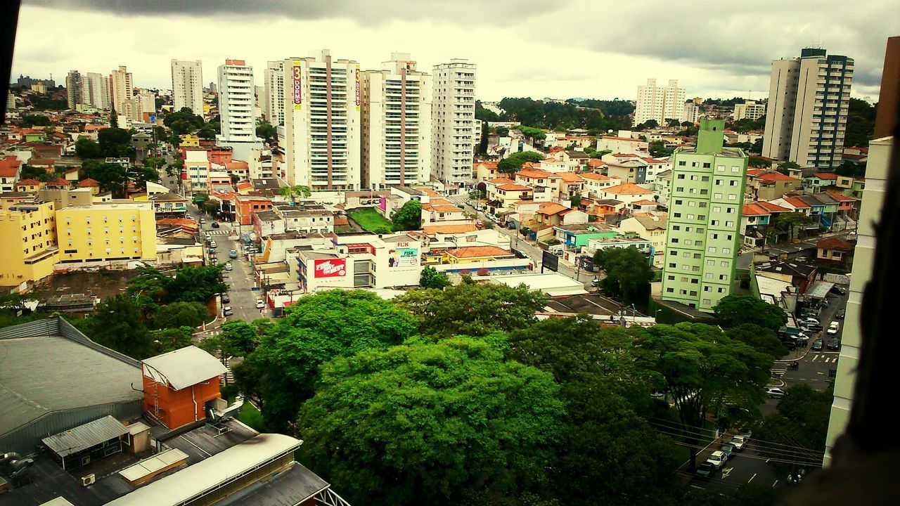 building exterior, architecture, built structure, city, cityscape, sky, residential district, residential building, tree, residential structure, cloud - sky, high angle view, crowded, cloudy, house, city life, building, cloud, skyscraper, tall - high