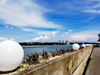 White railing by sea against sky