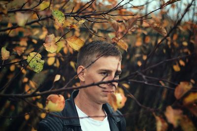 Portrait of young man with autumn leaves