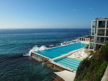 High angle view of swimming pool by sea against clear sky