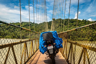 Solo rider loaded motorcycle parked isolated on suspension bridge