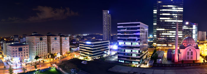 Illuminated buildings in city against sky at night