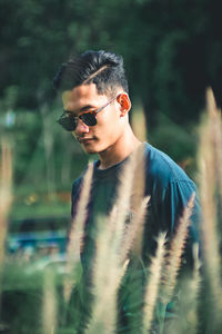 Portrait of young man wearing sunglasses standing outdoors