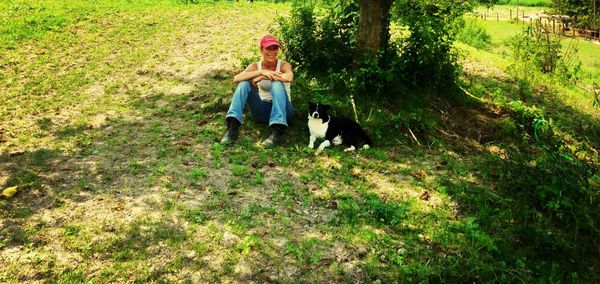 Full length of woman relaxing on grassy field