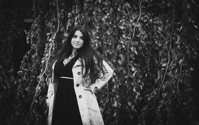 Portrait of woman standing against plants