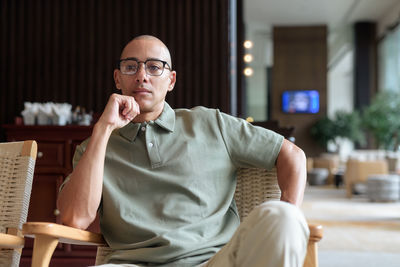 Young man using mobile phone while sitting on chair
