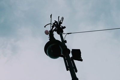 Low angle view of weather vane against sky