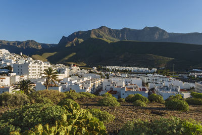 High angle view of townscape and mountains against clear sky