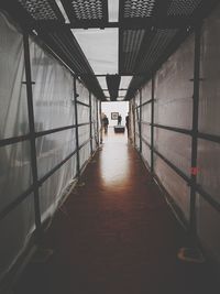 Rear view of person walking on corridor of building