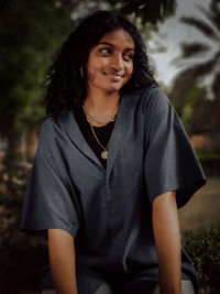 Portrait of a smiling young woman sitting outdoors