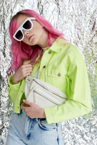 Woman wearing sunglasses standing by plants