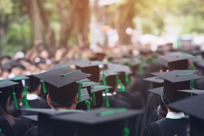 Rear view of people wearing graduation hats