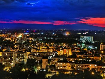 Illuminated cityscape against sky at night