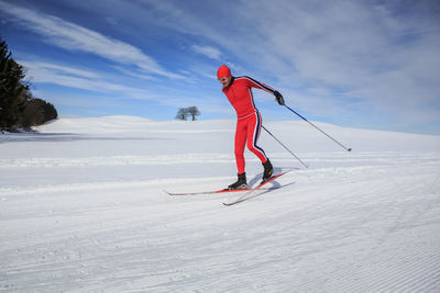 Man skiing on snowcapped mountain against sky