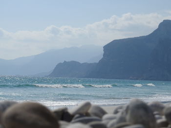 Scenic view of sea and mountains against sky