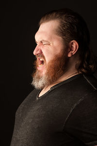 Portrait of smiling man against black background