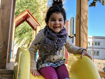 Portrait of smiling girl sitting outdoors