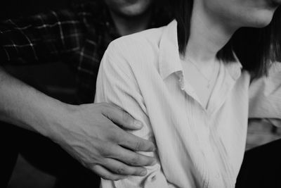 Midsection of boyfriend sitting with girlfriend