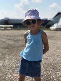 Portrait of cute girl standing at airport runway